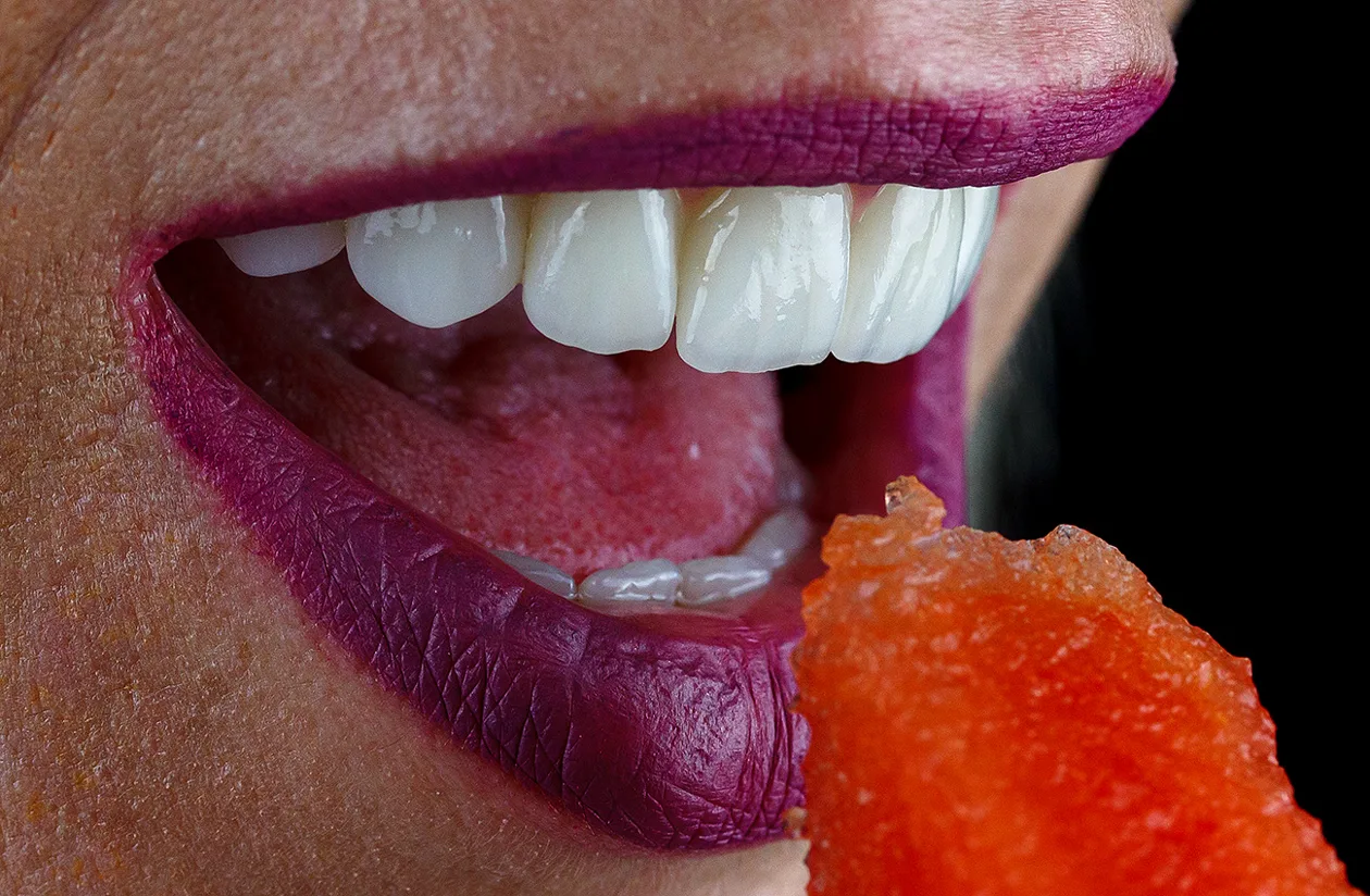 Sorriso de uma paciente a trincar fruta